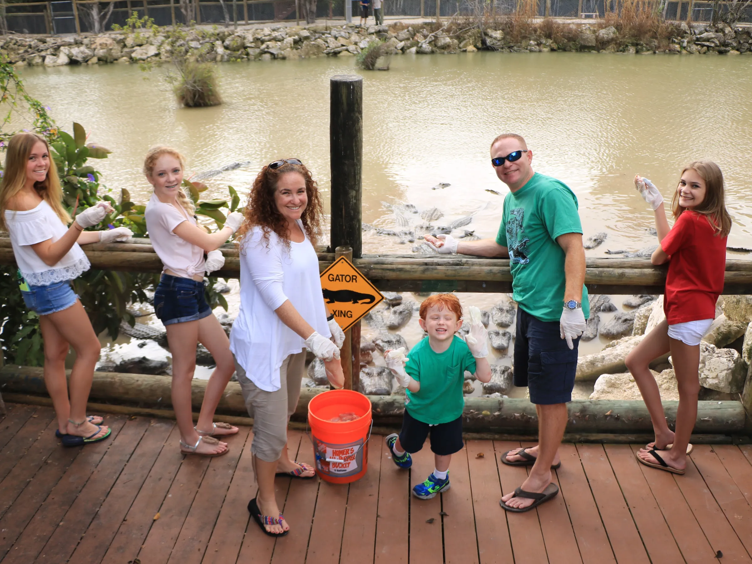 family smiling in front of alligator exhibit